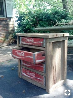 an old coca - cola cooler turned into a side table