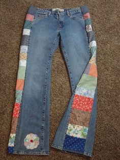 a pair of jeans with patches on them laying on the floor