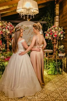 two women in dresses standing next to each other near a sign that says happily married