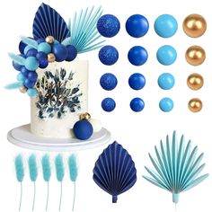 a cake with blue decorations on it next to some feathers and other items for decoration