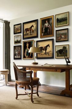 a room with pictures on the wall and a chair in front of a wooden desk