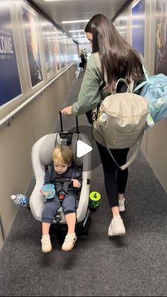 a woman pushing a stroller with a child in it and another person walking down an escalator