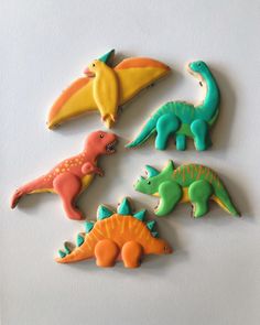 six decorated cookies in the shape of dinosaurs