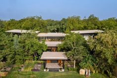 an aerial view of a house in the middle of trees and grass, surrounded by greenery