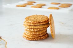 a stack of crackers sitting on top of a white counter next to some cookies