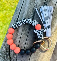 an orange and black beaded bracelet on a wooden table