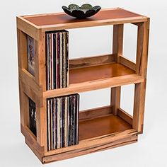 a wooden shelf with various cd's and cds on top, in front of a white background