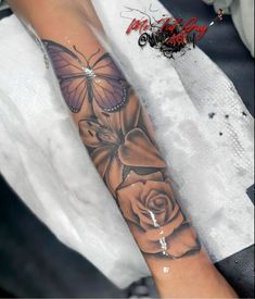 a woman's arm with a butterfly and rose tattoo on it