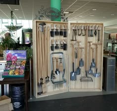 an open wooden box with gardening utensils in it and a sign on the wall