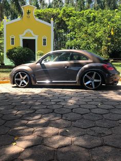 a gray car parked in front of a yellow house