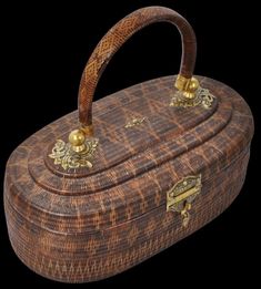 an old wooden box with gold decorations on the lid and handle, sitting against a black background