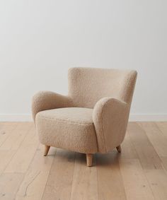 a white chair sitting on top of a hard wood floor next to a white wall