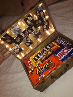 an open box filled with candy on top of a bed