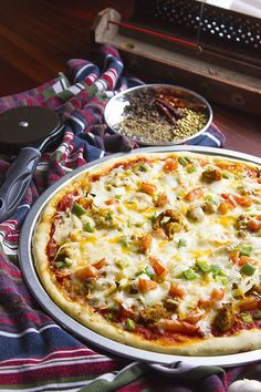 a pizza sitting on top of a pan covered in cheese and veggie toppings