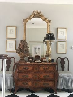 an antique dresser and mirror in a room with black and white checkered flooring