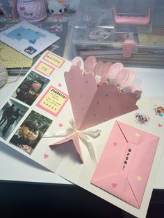 a table topped with lots of pink items on top of a white counter next to boxes