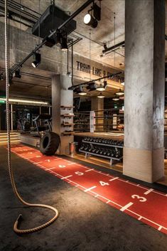 an indoor gym with treadmills and exercise mats on the floor in front of it