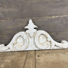 an old white wooden sign on the side of a wood planked wall with a star hanging from it's center