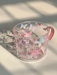 a glass cup with butterflies painted on it