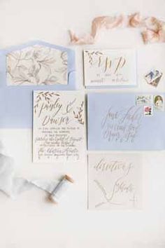 the wedding stationery is laid out on top of each other, including envelopes and stamps