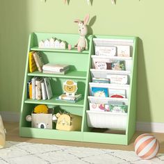 a child's book shelf with books and toys on it in a green room