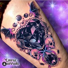 a woman's leg with a tattoo on it and skulls in the center, surrounded by stars