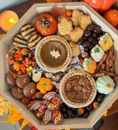 a wooden tray filled with lots of different types of food and decorations on top of a table