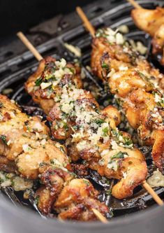 chicken skewers with parmesan cheese and herbs cooking in an air fryer