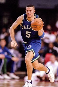 a basketball player dribbles the ball while running down the court with his foot