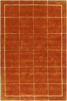 an orange area rug with squares and lines on the top, in front of a white background