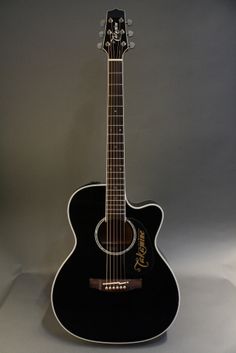 a black acoustic guitar sitting on top of a table