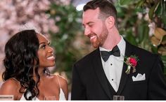 a man in a tuxedo and a woman in a white dress smile at each other