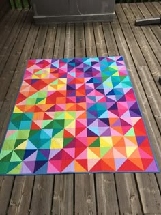 a multicolored area rug on a wooden deck