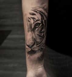 a black and white tiger tattoo on the arm