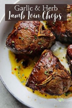 garlic and herbs lamb chops in a white bowl with lemon sauce on the side