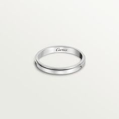 a white gold wedding band with the word culture engraved on it's side, in front of a plain background