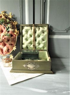 an open box sitting on top of a table next to a vase with flowers in it