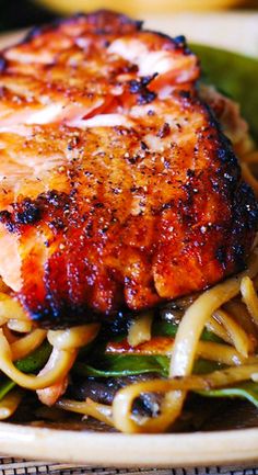 a close up of a plate of food with meat and noodles on it's side