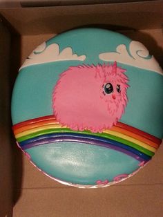 a cake in the shape of a rainbow with a pink animal on it