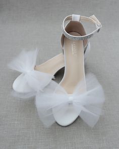 "Classy satin block heel with rows of rhinestones on ankle strap and added soft tulle bow . Sparkly and glamour is great combination and will definitely be a favorite. ** YOU CAN CHOOSE TO DO SHOES WITHOUT TULLE BOW - OPTION IS AVAILABLE AT CHECKOUT ** DETAILS: FIT: RUNS LARGE, ORDER ONE SIZE DOWN HEEL HEIGHT: 1.25 inches (kids) & 2 inches (women) COLORS AVAILABLE: White, Ivory, Navy, Burgundy and Champagne UPPER: Synthetic upper and lining MATERIALS: Mandmade outsole STYLE NAME: NAOMI Not s Open Toe Tulle Heels For Party, Tulle Open Toe Heels For Party, Ankle Strap Tulle Heels For Parties, Tulle Ankle Strap Heels For Party, Summer Wedding Tulle Heels, Wedding Ankle Strap Sandals With Satin Bow, White Bridal Shoes, Tulle Bow, Ivory Wedding Shoes