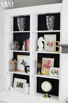 a white bookcase filled with pictures and vases on top of it's shelves