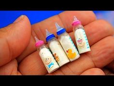 three small baby bottles are sitting in someone's hand