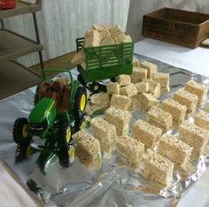 there is a cake made to look like a tractor and some blocks of rice on the table