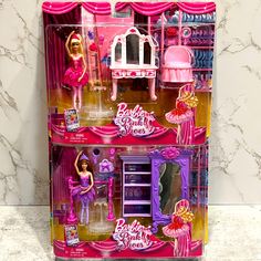 the barbie doll house is pink and has two dolls in it's display case