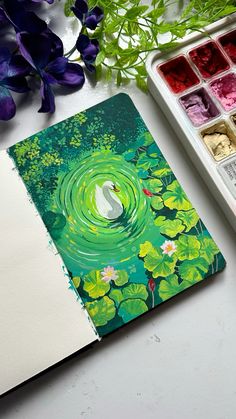 an open notebook sitting on top of a table next to water lilies