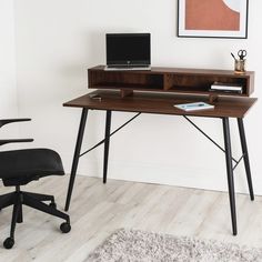 a desk with a laptop on it next to a chair