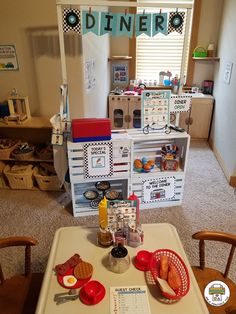 a table with some food on top of it in a room filled with wooden chairs