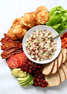 a platter filled with meat, bread and vegetables