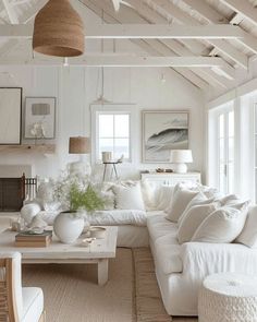 a living room filled with white furniture and lots of pillows on top of it's couches