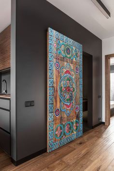 an abstract painting is displayed on the wall in this modern kitchen with wood flooring